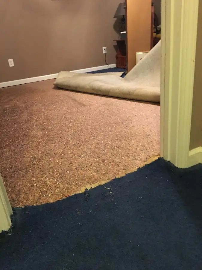 Carpet pad removal revealing water damage during Water Mitigation Services in Verdigris